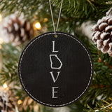 Black leatherette round Christmas ornament laser engraved with the Georgia LOVE Stacked design, hanging on a tree
