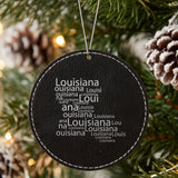 Black leatherette round Christmas ornament laser engraved with the Louisiana Word Cloud design, hanging on a tree