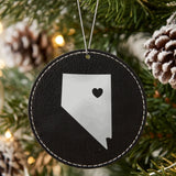 Black leatherette round Christmas ornament laser engraved with the Nevada Heart Accent design, hanging on a tree