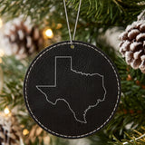 Black leatherette round Christmas ornament laser engraved with the Texas Classic Outline design, hanging on a tree