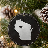 Black leatherette round Christmas ornament laser engraved with the Wisconsin Heart Accent design, hanging on a tree