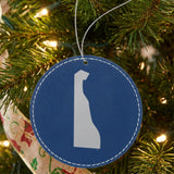 Blue leatherette round Christmas ornament laser engraved with the Delaware Engraved State design, hanging on a tree