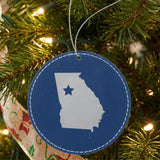 Blue leatherette round Christmas ornament laser engraved with the Georgia Star Accent design, hanging on a tree