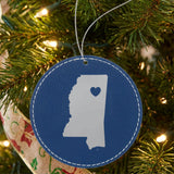 Blue leatherette round Christmas ornament laser engraved with the Mississippi Heart Accent design, hanging on a tree