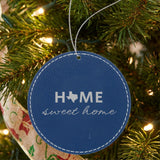 Blue leatherette round Christmas ornament laser engraved with the Texas Home Sweet Home design, hanging on a tree