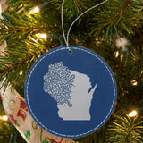 Blue leatherette round Christmas ornament laser engraved with the Wisconsin Floral Damask design, hanging on a tree