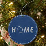 Blue leatherette round Christmas ornament laser engraved with the Wisconsin HOME Outline design, hanging on a tree