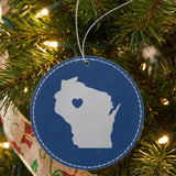 Blue leatherette round Christmas ornament laser engraved with the Wisconsin Heart Accent design, hanging on a tree