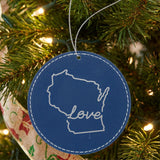 Blue leatherette round Christmas ornament laser engraved with the Wisconsin Hand-Drawn Love design, hanging on a tree