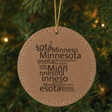 Brown leatherette round Christmas ornament laser engraved with the Minnesota Word Cloud design, hanging on a tree