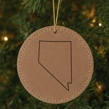 Brown leatherette round Christmas ornament laser engraved with the Nevada Classic Outline design, hanging on a tree