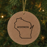 Brown leatherette round Christmas ornament laser engraved with the Wisconsin Brush Lettering design, hanging on a tree