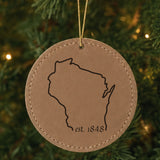 Brown leatherette round Christmas ornament laser engraved with the Wisconsin Est. 1848 design, hanging on a tree