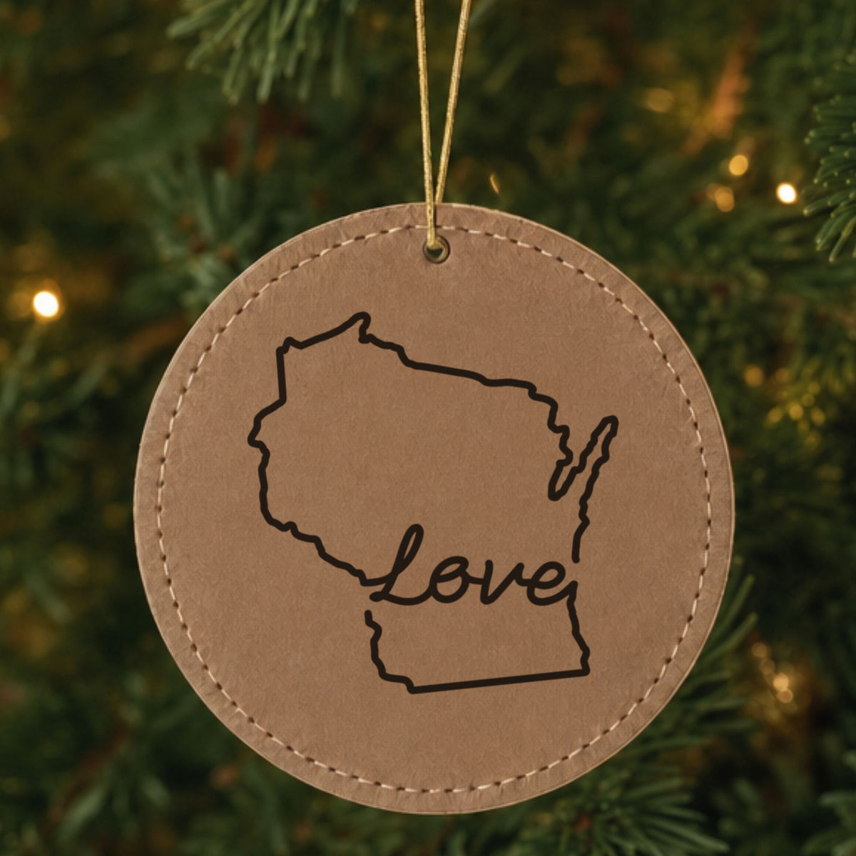 Brown leatherette round Christmas ornament laser engraved with the Wisconsin Hand-Drawn Love design, hanging on a tree