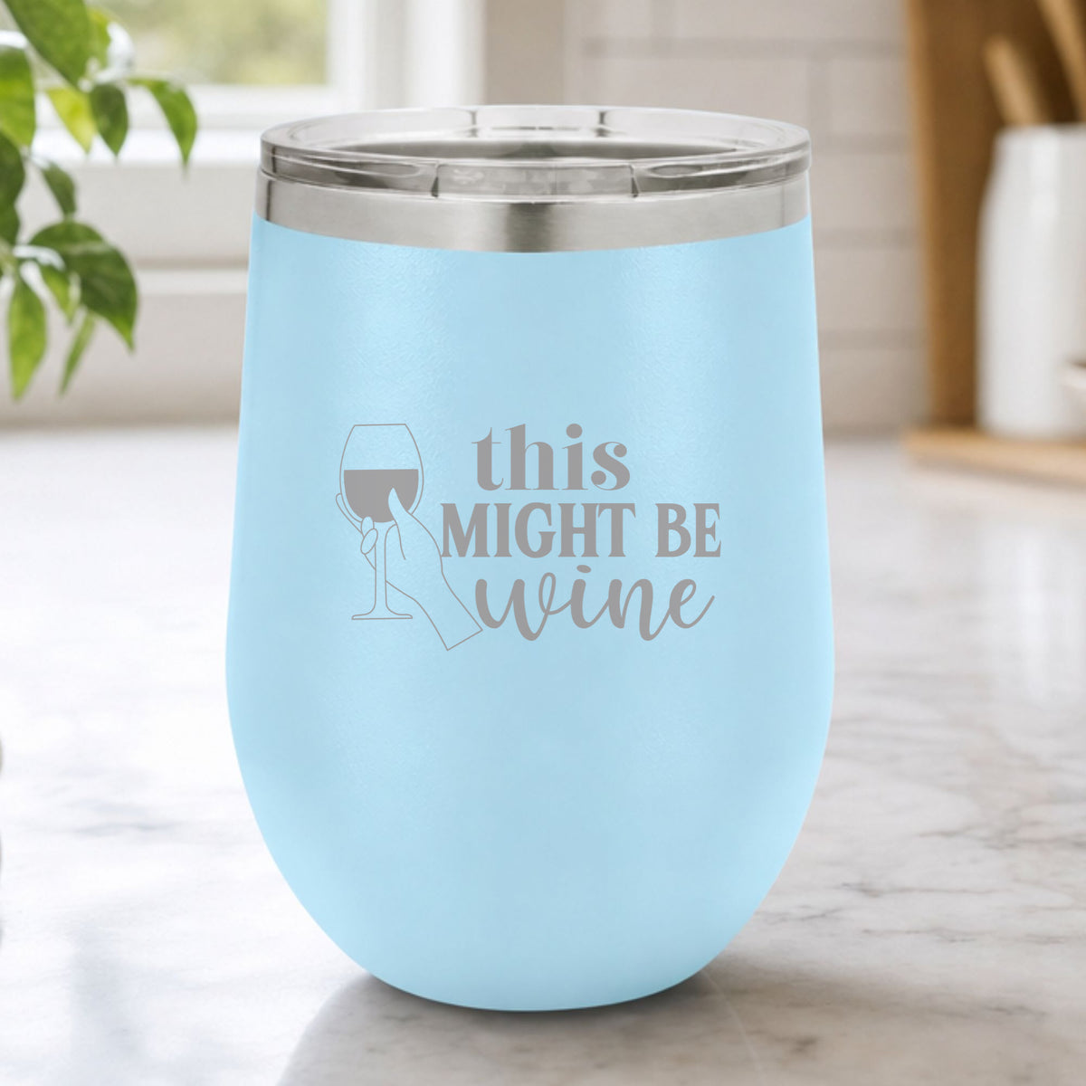 Light Blue 12 oz stemless wine tumbler laser engraved with "This Might Be Wine", on a kitchen counter