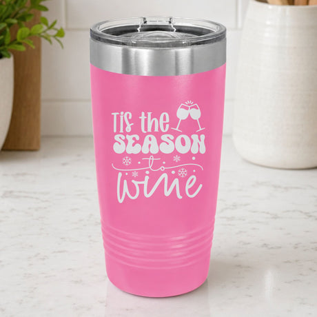 Pink 20 oz tumbler laser engraved with "'Tis the Season to Wine", on a kitchen counter