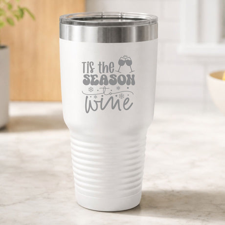 White 30 oz tumbler laser engraved with "'Tis the Season to Wine", on a kitchen counter