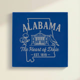 Close up of the Alabama design engraved on Blue leatherette: the capitol building, a cotton boll and a yellowhammer, "The Heart of Dixie", EST. 1819