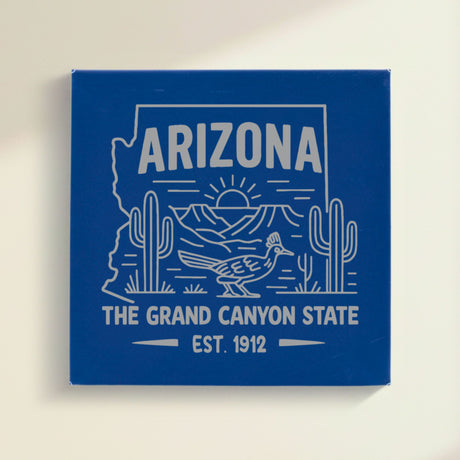Close up of the Arizona design engraved on Blue leatherette: saguaro cactus, a roadrunner and the Grand Canyon at sunrise, "The Grand Canyon State", EST. 1912