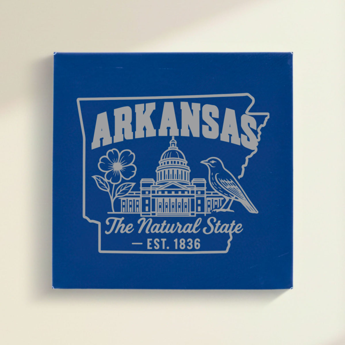 Close up of the Arkansas design engraved on Blue leatherette: the capitol dome, an apple blossom and a mockingbird, "The Natural State", EST. 1836