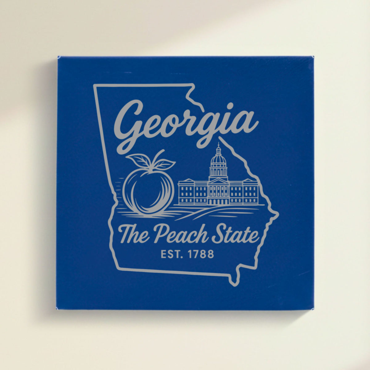 Close up of the Georgia design engraved on Blue leatherette: a peach and the capitol dome, "The Peach State", EST. 1788