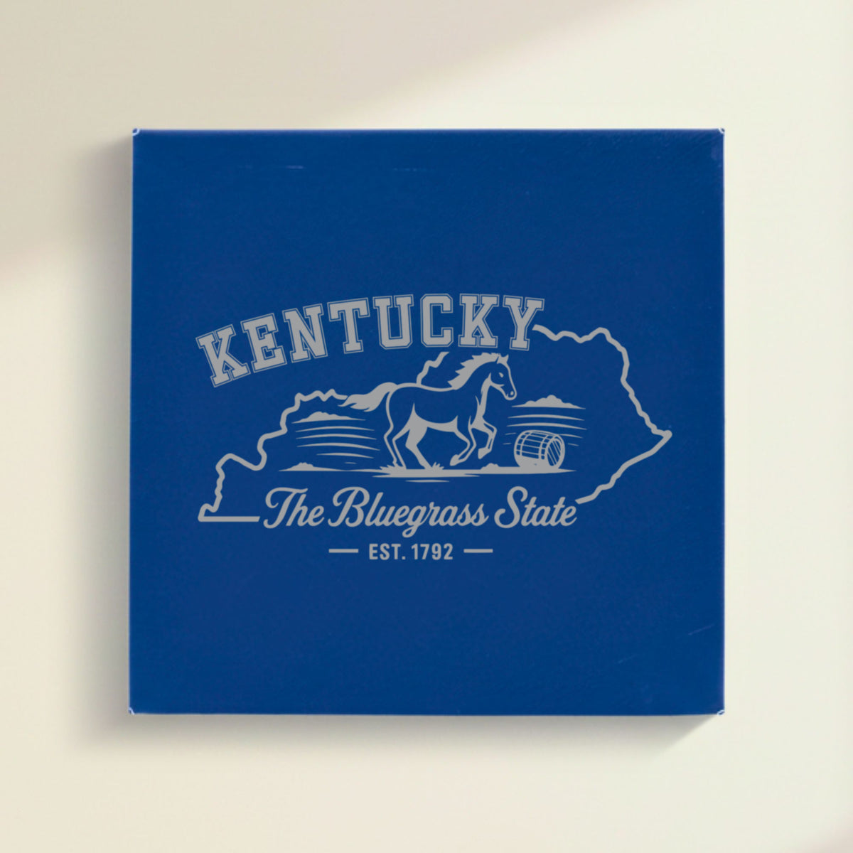 Close up of the Kentucky design engraved on Blue leatherette: a galloping horse and a bourbon barrel, "The Bluegrass State", EST. 1792