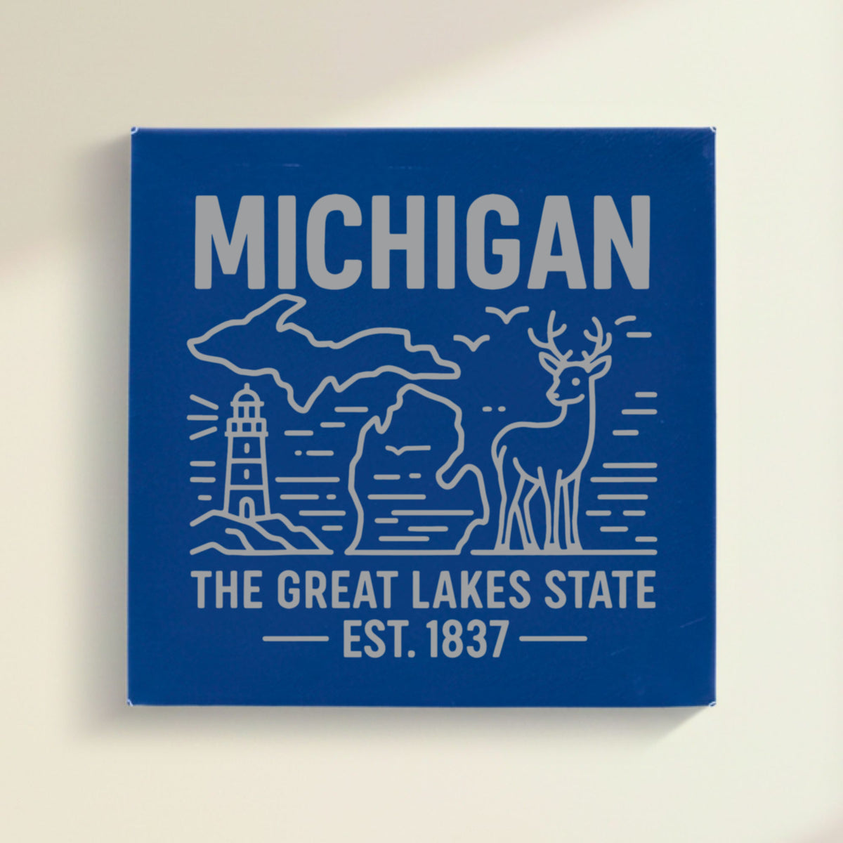 Close up of the Michigan design engraved on Blue leatherette: a lighthouse, a whitetail buck and both peninsulas, "The Great Lakes State", EST. 1837