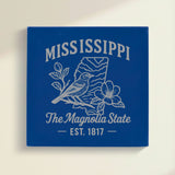 Close up of the Mississippi design engraved on Blue leatherette: a mockingbird and magnolia blossoms, "The Magnolia State", EST. 1817