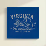 Close up of the Virginia design engraved on Blue leatherette: a cardinal and dogwood blossoms, "The Old Dominion", EST. 1788