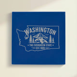 Close up of the Washington design engraved on Blue leatherette: an orca, Mount Rainier and evergreens, "The Evergreen State", EST. 1889