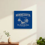 Blue leatherette wall sign engraved with a Minnesota design of a loon, a canoe and lakeside pines, hanging on a wall