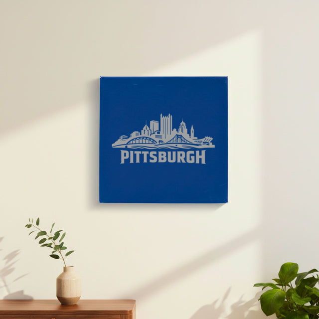Blue leatherette wall sign engraved with the Pittsburgh, Pennsylvania skyline, hanging on a wall