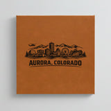 Close up of the Aurora, Colorado skyline engraved on Brown leatherette