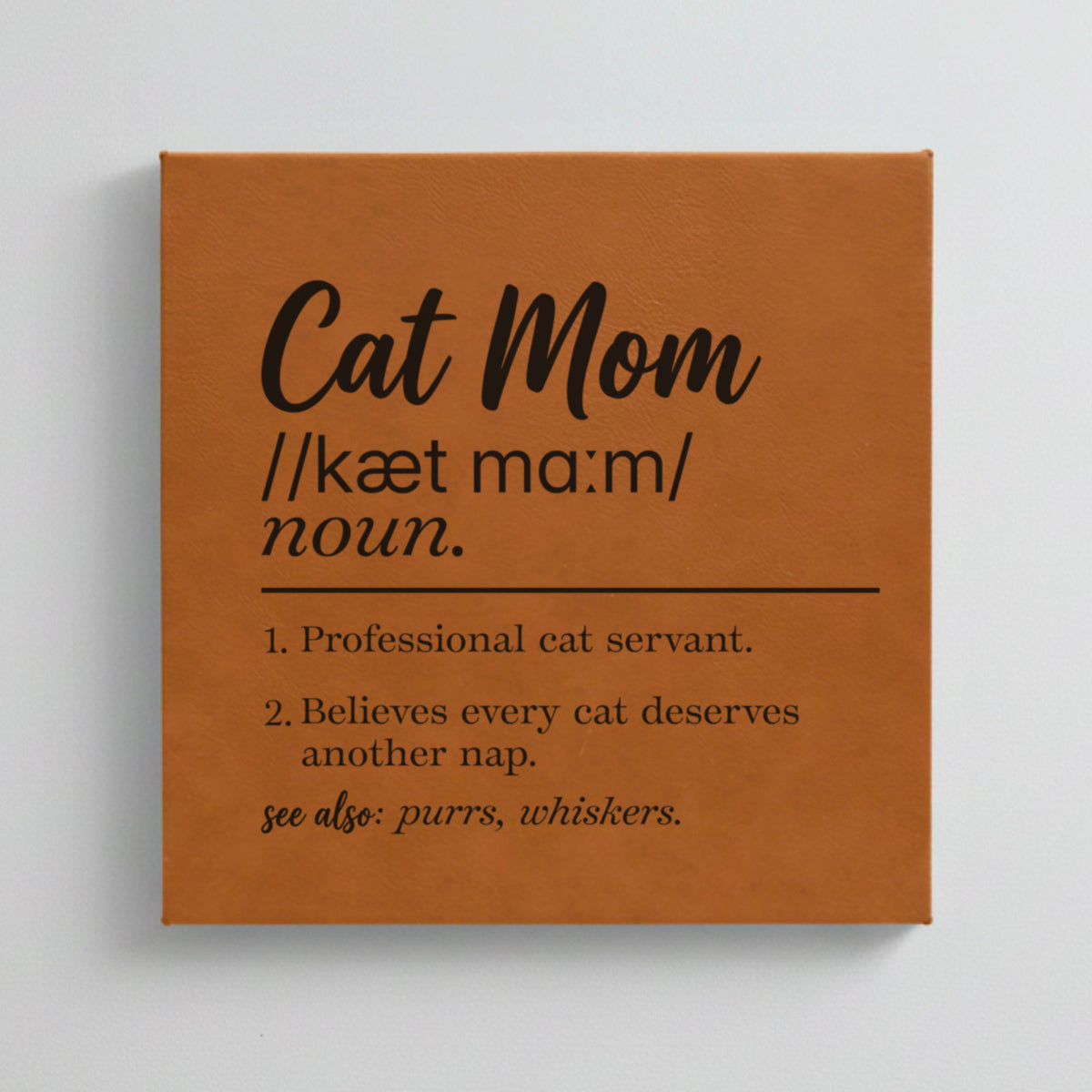 Close-up of the brown leatherette wall sign engraved with the Cat Mom dictionary definition