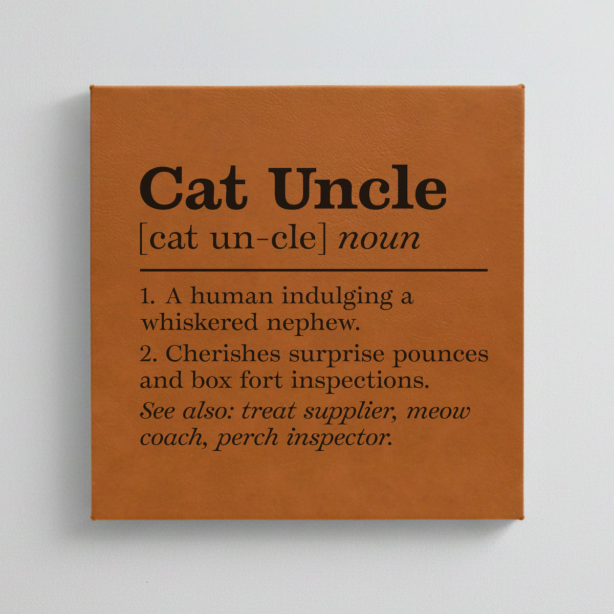 Close-up of the brown leatherette wall sign engraved with the Cat Uncle dictionary definition