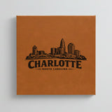 Close up of the Charlotte, North Carolina skyline engraved on Brown leatherette