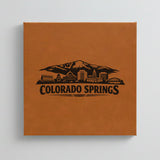 Close up of the Colorado Springs, Colorado skyline engraved on Brown leatherette
