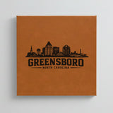 Close up of the Greensboro, North Carolina skyline engraved on Brown leatherette