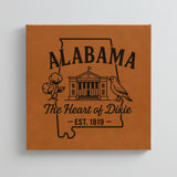 Close up of the Alabama design engraved on Brown leatherette: the capitol building, a cotton boll and a yellowhammer, "The Heart of Dixie", EST. 1819