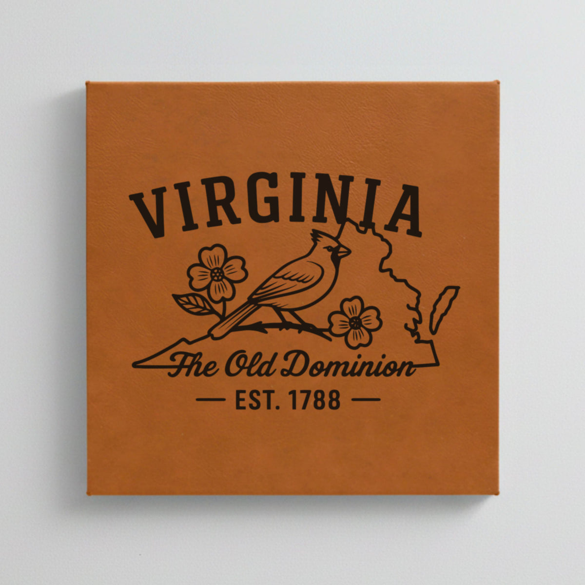 Close up of the Virginia design engraved on Brown leatherette: a cardinal and dogwood blossoms, "The Old Dominion", EST. 1788
