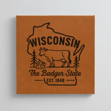 Close up of the Wisconsin design engraved on Brown leatherette: a dairy cow and a wedge of cheese, "The Badger State", EST. 1848