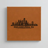 Close up of the Philadelphia, Pennsylvania skyline engraved on Brown leatherette