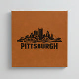 Close up of the Pittsburgh, Pennsylvania skyline engraved on Brown leatherette