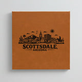 Close up of the Scottsdale, Arizona skyline engraved on Brown leatherette