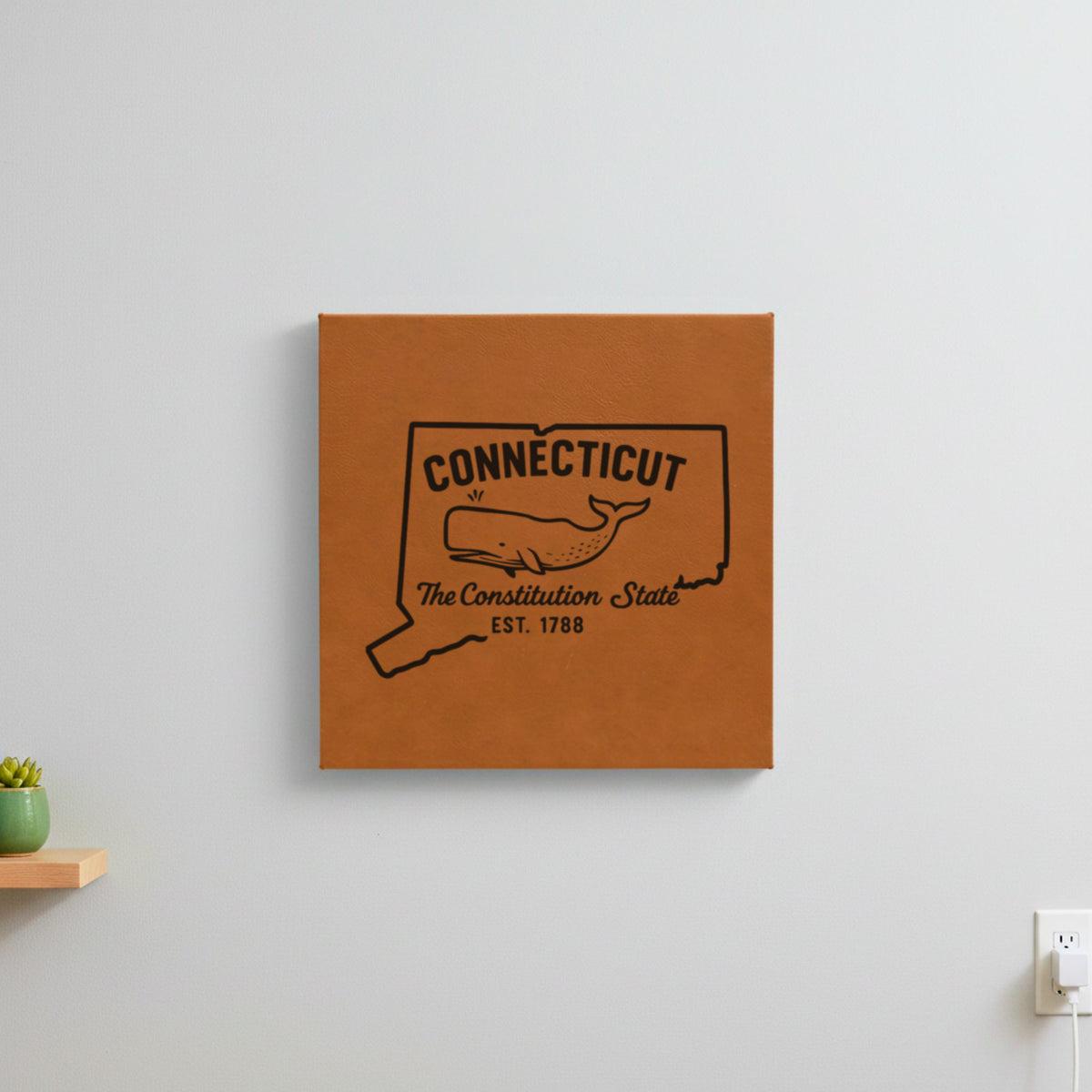 Brown leatherette wall sign engraved with a Connecticut design of a sperm whale, hanging on a wall