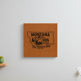 Brown leatherette wall sign engraved with a Montana design of a grizzly bear, a trout and mountain peaks, hanging on a wall