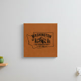 Brown leatherette wall sign engraved with a Washington design of an orca, Mount Rainier and evergreens, hanging on a wall
