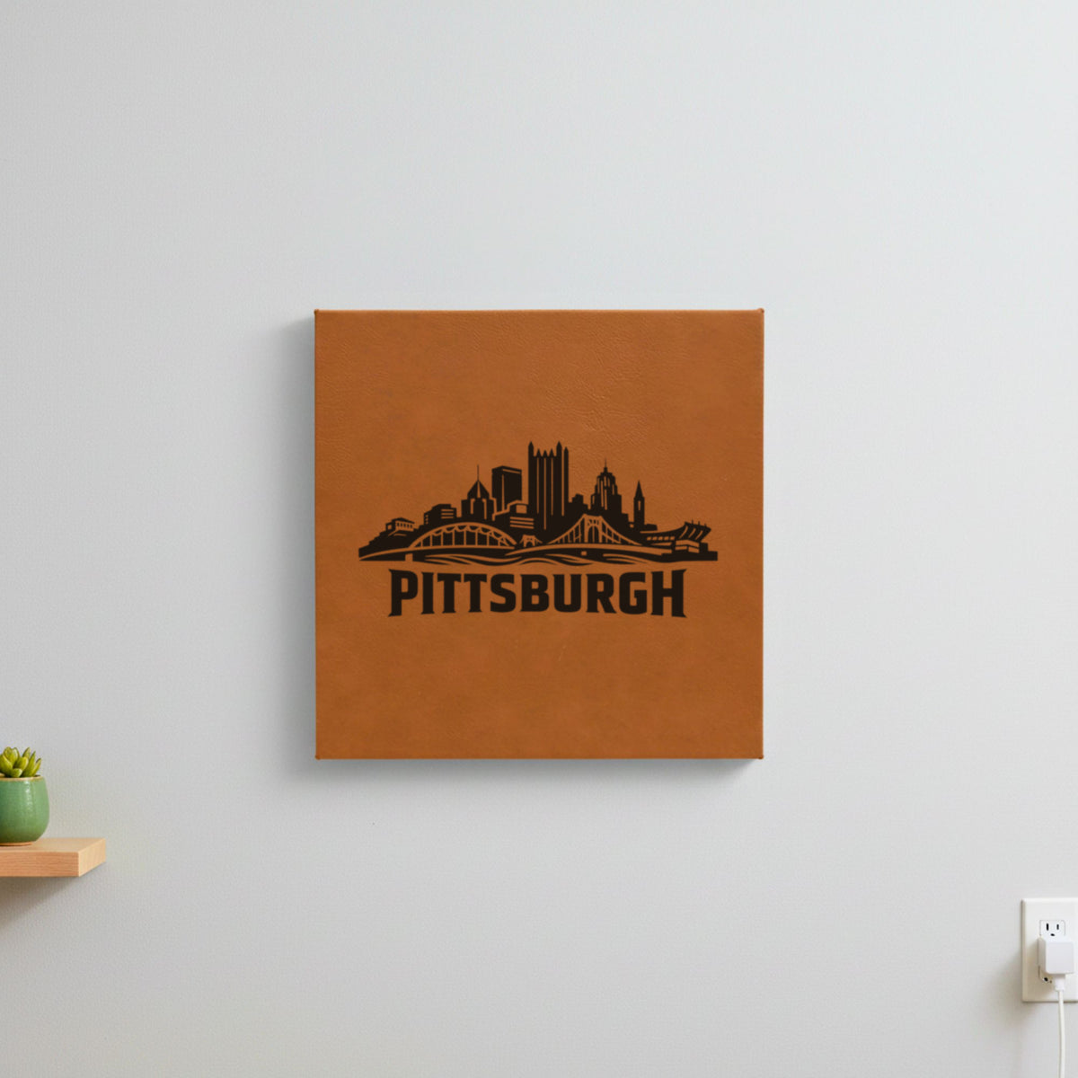 Brown leatherette wall sign engraved with the Pittsburgh, Pennsylvania skyline, hanging on a wall