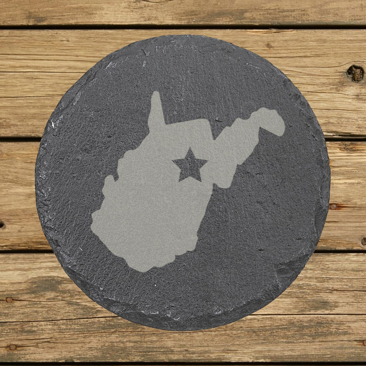 West Virginia round slate coaster engraved with the state shape and a star