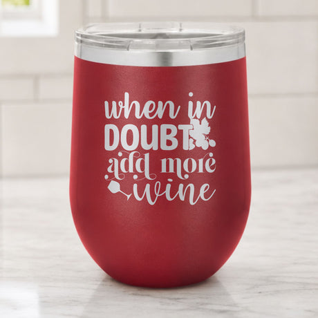 Maroon 12 oz stemless wine tumbler laser engraved with "When in Doubt, Add More Wine", on a kitchen counter